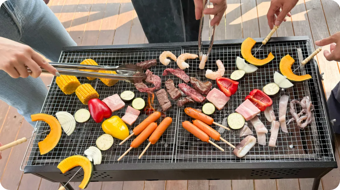 BBQコンロで焼かれている肉や野菜などの食材
